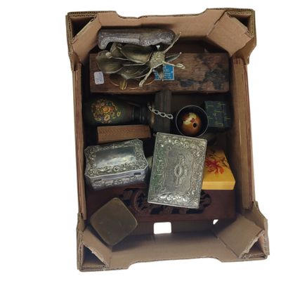 a cardboard box filled with assorted items on a white surface