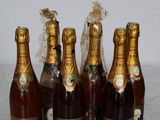 six bottles of champagne are lined up on a marble table