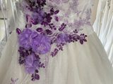 a dress with purple flowers on it in a store