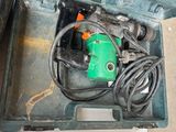 a small green tool in a case on the floor