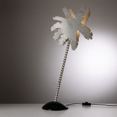 the palm tree lamp has a metal base and a gold leaf on it