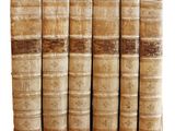 plusieurs vieux livres sont empilés sur une surface blanche