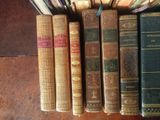 several old books are lined up in a row on a table
