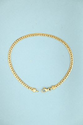a gold chain bracelet with a clasp on a blue background