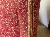 red upholstered chair with gold trim and floral upholstered back