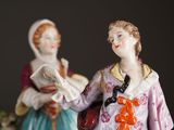 two figurines that are standing next to each other