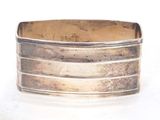silver cuff bracelet with wavy design on a white background