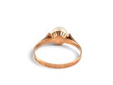 a close up of a gold ring with a pearl in it