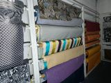many different colored fabrics on a shelf in a room