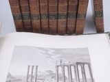 un livre ouvert posé sur une table à côté d'une pile de livres