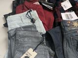 several pairs of men ' s jeans in a box with tags on them