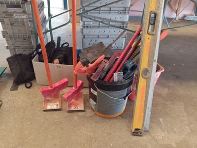 un seau de peinture et des outils posés par terre dans un immeuble