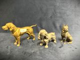three golden figurines of dogs with tags on their backs