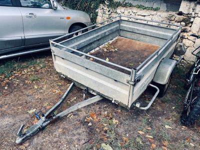 a small trailer that is parked next to a car
