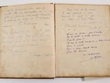 an old book with writing on it sitting on top of a table