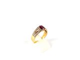 gros plan d'une bague en or avec une pierre en rubis
