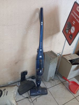 un aspirateur posé par terre à côté d'un panneau