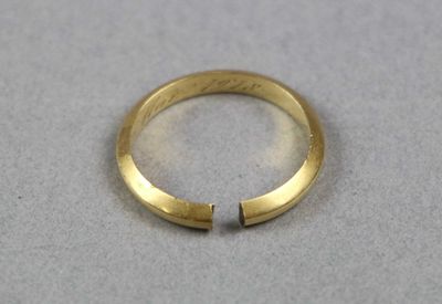 gros plan d'une bague en or sur une surface blanche