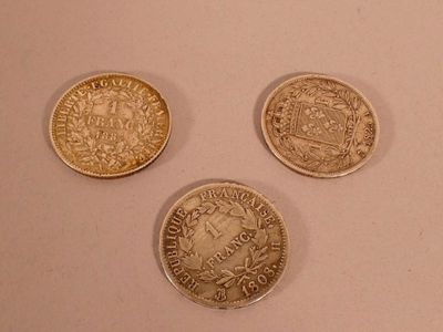 three different types of coins sitting on a white surface