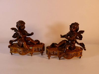 paire de figurines anciennes en bronze représentant des chérubins, posées sur une table
