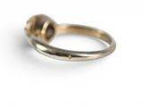 a close up of a gold ring with a ball on it
