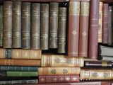 many books that are stacked on a shelf together