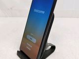 a close up of a cell phone on a stand with a welcome screen