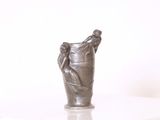 une statue représentant une main tenant une bouteille posée sur une table
