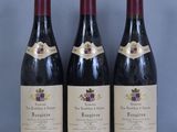 trois bouteilles de vin sont alignées sur une table
