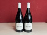 trois bouteilles de vin sont posées sur un comptoir devant un mur rouge