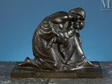 an image of a bronze statue of a woman holding a child