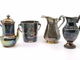 trois vases argentés et bleus posés les uns à côté des autres sur une surface blanche
