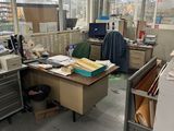 un bureau en désordre, avec beaucoup de bric-à-brac par terre