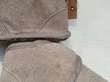 pair of grey sued boots with a brown sole and a brown sole