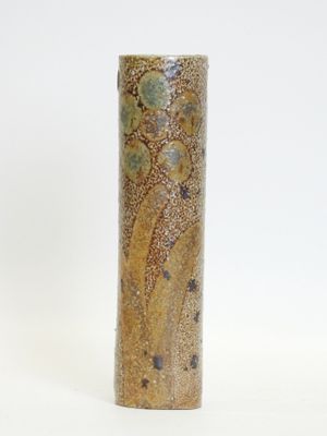 a tall vase with a design on it on a white surface