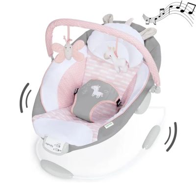Le berceau du bébé est rose et blanc, orné de notes de musique tout autour.