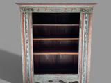 an old wooden bookcase with two shelves and a door