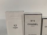 three boxes of chanel perfume sitting on a white surface