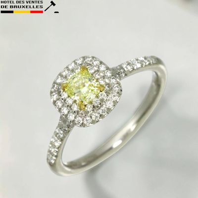 une bague de fiançailles sertie d'un diamant jaune entouré de diamants blancs