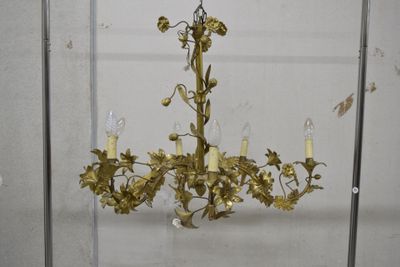 un lustre en or d'où pendent des fleurs et des bougies