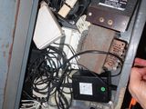 a person holding a pair of scissors in front of a cabinet full of electronic equipment