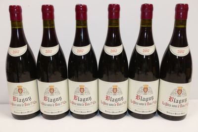 six bouteilles de vin rouge sont alignées sur une surface blanche