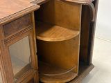 a wooden cabinet with a glass door and a shelf