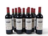 six bottles of red wine lined up in a row on a white surface