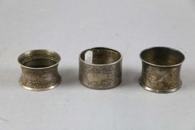 three antique silver napkin holders sitting next to each other on a table