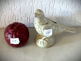 une figurine d'oiseau posée à côté d'une pomme sur une table