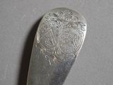 a silver spoon with a design on it on a table