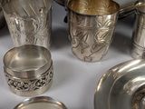 a silver plate and silver cups on a table