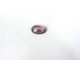 une pierre ovale violette posée sur une surface blanche, avec un fond blanc
