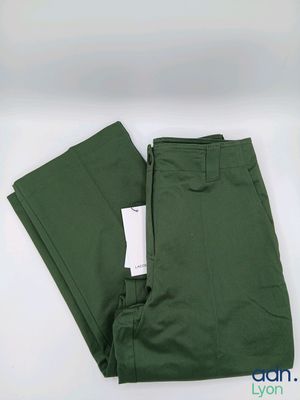 Le pantalon est vert et porte une étiquette blanche.